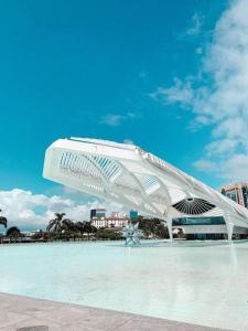 a white umbrella sitting in the middle of a pool at Studio Orion in Rio de Janeiro