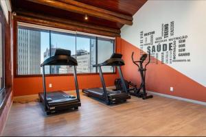 a gym with three exercise bikes in a room with a window at Studio Orion in Rio de Janeiro
