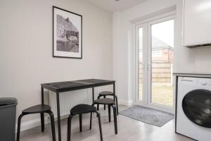 cocina con mesa negra y taburetes en una habitación en Three Bedroom House by Brookland Stays Serviced Accommodation Short Lets Manchester with Free WiFi, en Mánchester 3 fotos más