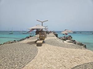 - une plage avec des tables, des parasols et l'océan dans l'établissement Tortuga beach resort Penthouse apartment for holiday rental, à Prainha