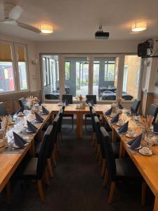 a large room with long wooden tables and chairs at Hotel Restaurant Harrier Hof in Brake