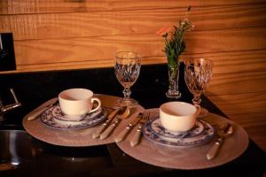 una mesa con dos tazas y dos vasos y cubiertos en Blue Sunset 4, en Urubici 19 fotos más