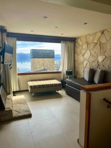 a living room with a large window and a couch at Bahia Paraiso Apart & Suites in San Carlos de Bariloche