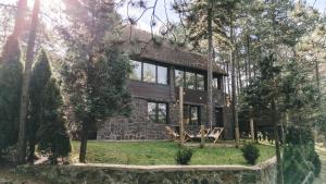 uma casa na floresta com uma fachada de pedra em Drey Divcibare em Divčibare