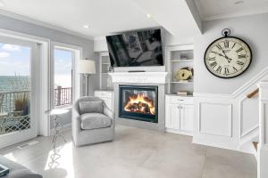 a living room with a fireplace and a clock at Sunrise Waterfront Retreat in Milford