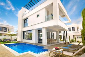 een huis met een zwembad ervoor bij Villa Amity in Protaras