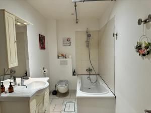 a bathroom with two sinks and a tub and a toilet at La Marquise Duplex 2 Ch avec Terrasse et Climatisation in Socourt