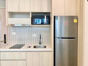 a kitchen with a stainless steel refrigerator and a sink at Olympus City Garden 1 Bedroom in Pattaya South