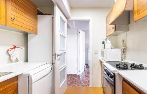 eine Küche mit weißen Arbeitsplatten und Holzschränken in der Unterkunft Beautiful Apartment In El Campello in El Campello