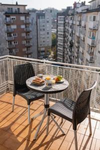 einen Tisch und Stühle auf einem Balkon mit Essen drauf in der Unterkunft Apartment Amara AMONAREN ETXEA Free WiFi, ROOMS, rent parking in San Sebastián