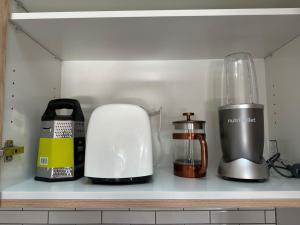 a kitchen counter with various appliances on a shelf at Amazing Retreat in Queenstown in Frankton Wharf