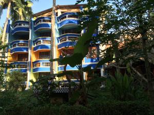 un edificio con balcones azules frente a un árbol en Anitha's Garden Stay, en Kovalam