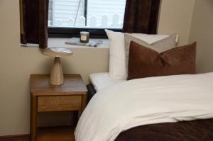 a bedroom with a bed and a table with a window at Istay - Parkgata 40 in Tromsø