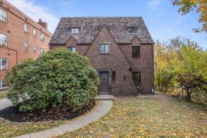 an old brick house with a tree in front of it at The Walnut Suites - The Emerald Suite in Pittsburgh