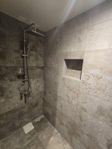 a bathroom with a shower with a stone wall at La Luna in Bangui