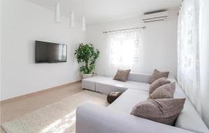 a white living room with a couch and a tv at Awesome Apartment In Sutivan With Wifi in Sutivan