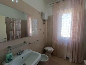 ein Badezimmer mit Waschbecken, Toilette und Fenster in der Unterkunft Attico Stadio in Pescara