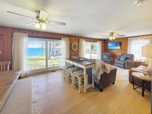 a living room with a table and a couch at Grassy Knoll Retreat on the Big Spirit Lake in Orleans