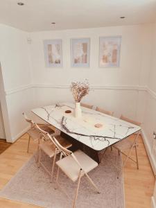 a dining room with a marble table and chairs at The Secret Garden Retreat With Hot Tub in Manchester