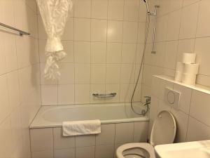 a bathroom with a toilet and a bath tub at Cozy 2BR near Lake - Wille 8 in Zürich
