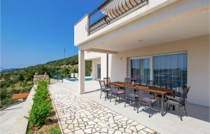 a patio with a wooden table and chairs at Cozy Home In Mundanije With Wifi in Mundanije