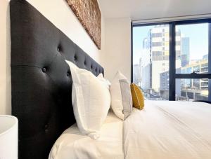 Giường trong phòng chung tại Aura on Lonsdale