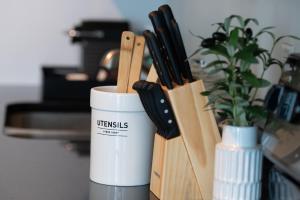 a white coffee cup next to a bunch of knives at Monte Carlo by Miami Vacations in Miami Beach