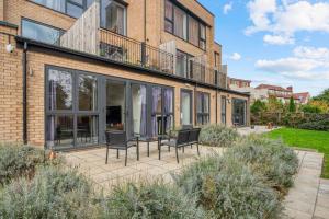 een huis met een patio met stoelen erop bij 3-Bed, 2-Bath Wembley Apartment with Free Parking in Londen