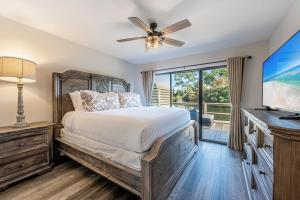 Un dormitorio con una cama y un televisor de pantalla plana. en Beachwalk Villa 5202, en Destin 55 fotos más