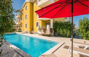 czerwony parasol przy basenie w obiekcie Cozy Apartment In Salatici With Jacuzzi w mieście Salatić