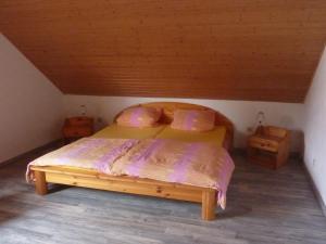 ein Schlafzimmer mit einem Holzbett im Dachgeschoss in der Unterkunft Ferienwohnung Schildwache in Homburg