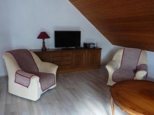 ein Wohnzimmer mit 2 Stühlen und einem TV in der Unterkunft Ferienwohnung Schildwache in Homburg