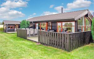 a house with a wooden fence in a yard at Holiday Home Sofievej Knebel X in Skødshoved Strand