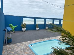a hot tub on a patio with the ocean in the background at Pé na areia apto Rassy in Itapoa