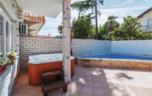 a bath tub in a backyard with a swimming pool at Amazing Home In Zadar With Sauna in Zadar