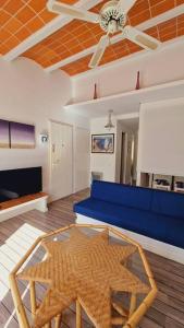 a living room with a blue couch and a table at Es Racó Blau in Cadaqués