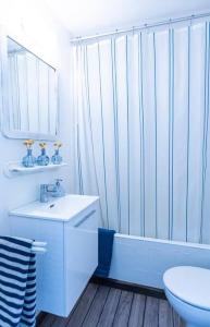 a white bathroom with a tub and a sink and a toilet at Es Racó Blau in Cadaqués
