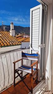a chair on a balcony with a view of a city at Es Racó Blau in Cadaqués