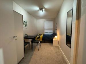 a small room with a bed and a table and a bedroom at City Rd C - Central Location Long Stay by ShortStayUK in Bristol
