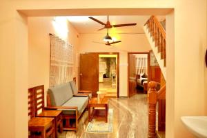 a living room with a couch and a chair at Blue home stay- 10min walk to kanyakumari beach in Kanyakumari
