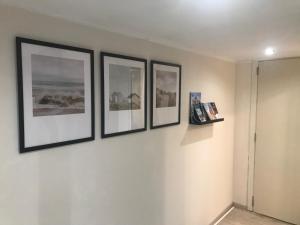 four pictures on a wall in a room at Maison des Dunes in Oostduinkerke
