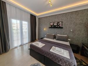 una camera da letto con un letto grande e una grande finestra di Hotel Valerios a Kriopigi