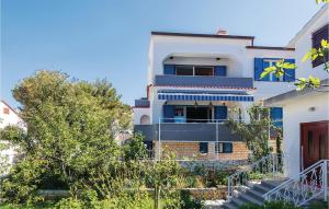a white house with blue windows and stairs at Three-Bedroom Holiday Home In Zaboric in Zaboric