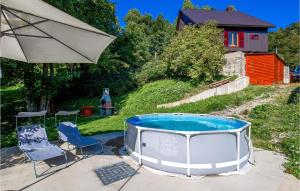 un bain à remous avec deux chaises et un parasol dans l'établissement Awesome Apartment In Lokve, à Mrzla Vodica