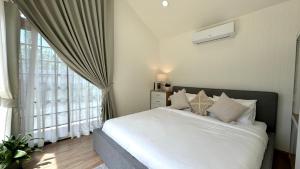 a bedroom with a bed and a large window at Sea Salt Casa Bang Tao in Ban Thalat Choeng Thale