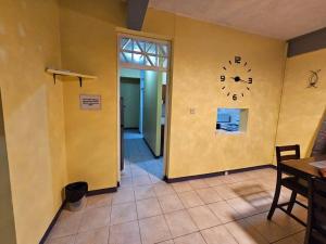 ein Zimmer mit einer Uhr an der Wand in der Unterkunft Alexander's Place in Roseau