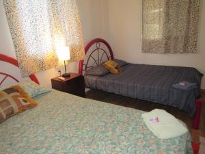 a bedroom with two beds and a lamp at La bamba surf house in Dolores Miramar