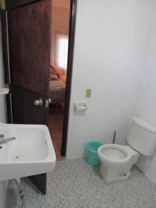 a bathroom with a white toilet and a sink at La bamba surf house in Dolores Miramar