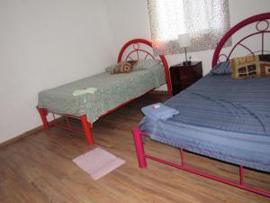a bedroom with two twin beds and a lamp at La bamba surf house in Dolores Miramar