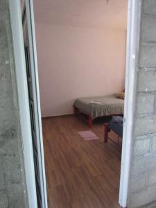 a small room with a bed and a floor at La bamba surf house in Dolores Miramar